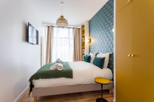 - une chambre avec un lit et une tête de lit bleue dans l'établissement CMG Charonne / Voltaire III, à Paris