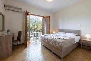 Schlafzimmer mit einem Bett, einem Schreibtisch und einem Fenster in der Unterkunft Maria Apartments Studios Epidavros in Antikes Epidauros