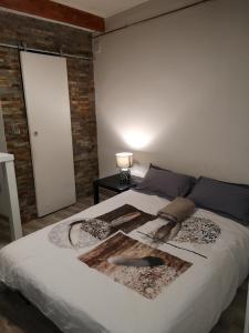 a bedroom with a white bed with a brick wall at studio hypercentre courteissade in Aix-en-Provence