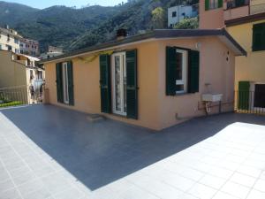 a house with a roof with green shutters at Riomaggiore Attico in Riomaggiore