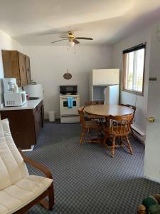 ein Wohnzimmer mit einem Tisch und eine Küche mit einem Sofa in der Unterkunft Fundy Rocks Motel in Hopewell Cape