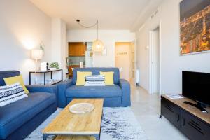 a living room with two blue couches and a table at bcn uniqhome in Barcelona