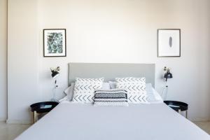 バルセロナにあるbcn uniqhomeのベッドルーム1室(白いベッド1台、黒い椅子2脚付)