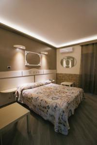 1 dormitorio con cama, mesa y espejo en Pensione Enea, en Nápoles