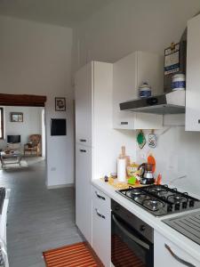 阿爾扎凱納的住宿－Appartamento " CENTRAL"，厨房配有白色橱柜和炉灶烤箱。