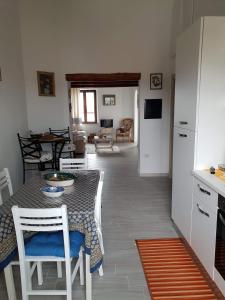 a kitchen and living room with a table and chairs at Appartamento " CENTRAL" in Arzachena