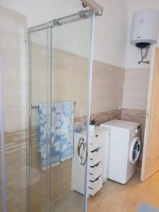 a bathroom with a washing machine and a washer and dryer at Appartamento " CENTRAL" in Arzachena