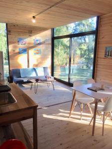 Habitación con mesas, sillas y ventana grande. en Cabañas Isla San Jose en Tigre