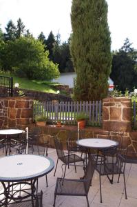 um pátio com mesas e cadeiras e uma cerca em La Petite Provence em Leisnig