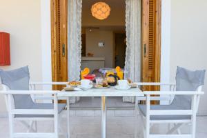 a dining room table with chairs and food on it at Maria Apartments Studios Epidavros in Ancient Epidauros