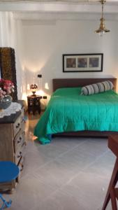 - une chambre avec un lit vert et une table dans l'établissement Attico in complesso turistico, à Policoro