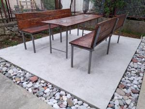 two benches and a table and a bench and rocks at Sweet Dream Rooms in Podgorica
