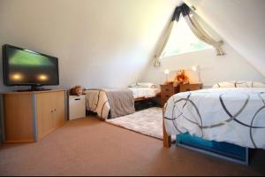 a bedroom with two beds and a tv in a room at Clifftop Chalet With Pool in Deal