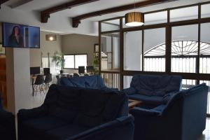 ein Wohnzimmer mit blauen Sofas und einem Tisch in der Unterkunft Hostales Juan de Austria I & II in Aguadulce