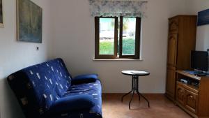 a living room with a blue couch and a window at Bungalow Perla in Funtana