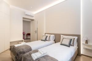 two beds in a bedroom with white and gray at Alchimia di Mare in La Spezia