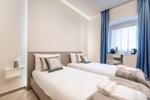 two beds in a room with blue drapes at Alchimia di Mare in La Spezia