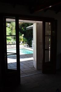 una porta aperta che conduce a una piscina all'aperto di Villa Violeta a Petrópolis