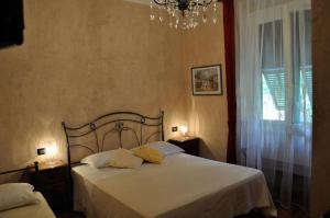 a bedroom with a bed with white sheets and a chandelier at Locanda Villa Moderna in Genoa
