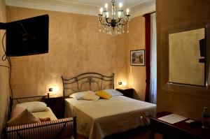 a bedroom with two beds and a chandelier at Locanda Villa Moderna in Genoa