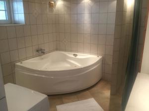 a white bath tub in a bathroom with a window at Cozy room in Kolding