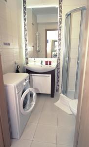 een badkamer met een wasmachine en een wastafel bij Apartament Zielone Tarasy 9C in Kołobrzeg