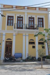 two motorcycles parked in front of a yellow building at Myrtia in Symi