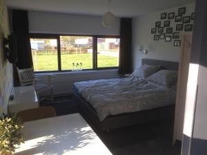 1 dormitorio con cama y ventana grande en B&B Nagele, en Nagele