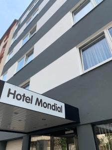 un panneau d'hôtel devant un bâtiment dans l'établissement Hotel Mondial Comfort - Frankfurt City Centre, à Francfort-sur-le-Main