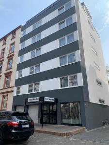 a black car parked in front of a building at Hotel Mondial Comfort - Frankfurt City Centre in Frankfurt/Main