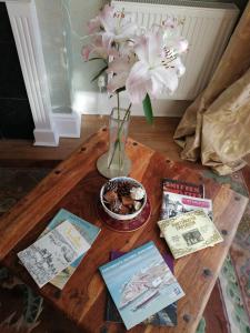 uma mesa com um vaso de flores e livros sobre ela em The Pier em Portsmouth