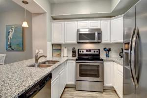 a kitchen with white cabinets and a stainless steel refrigerator at Nemo Cay 15122 in Corpus Christi