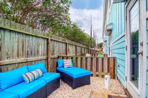 een patio met een blauwe bank en een hek bij Nemo Cay 15122 in Corpus Christi