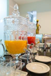 a glass jug of orange juice sitting on a table at Pousada Macdonald in Eunápolis +11 photos