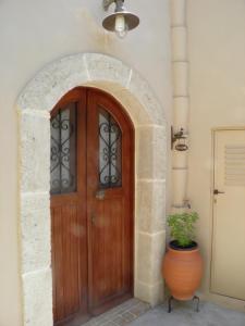 a wooden door in a stone archway with a plant at Kytherian Traditional Home in Friligkianika