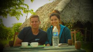 un hombre y una mujer sentados en una mesa con una botella de agua en Jungle House, en Yala