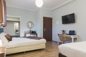a hotel room with two beds and a television at Dome Rooms Downtown in Chania Town