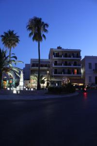 a large building with palm trees in front of it at Archontissa in Ermoupoli
