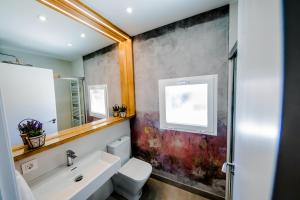 a bathroom with a sink and a toilet and a mirror at Casa Rural Peña Gamella in Herreros +49 photos