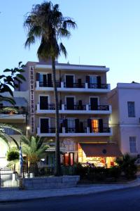 a tall building with a palm tree in front of it at Archontissa in Ermoupoli