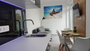 a kitchen with a sink and a table with chairs at Lakefive Apartments Balatonfüred in Balatonfüred