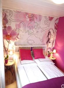 ein Schlafzimmer mit einem weißen Bett mit rosa Wänden in der Unterkunft Seependance in Grömitz