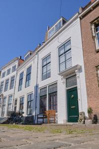 a white building with a green door on a street at Het Gecroonde Swaert B&B in Middelburg