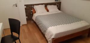 1 dormitorio con 1 cama y 1 silla en una habitación en Villa du Courboulay en Sargé Les Le Mans 