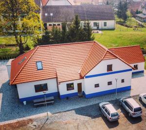 dom z dwoma samochodami zaparkowanymi przed nim w obiekcie Čechův dvůr w mieście Louka