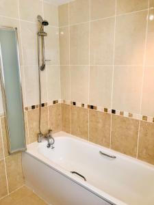 a bath tub in a bathroom with a shower at Chestnut Cottage, Shanklin Rural Retreat in Shanklin