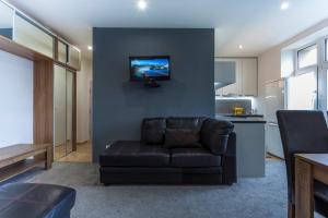 a living room with a couch and a television on a wall at Air-Conditioned Apartment Šancová - Old Town in Bratislava