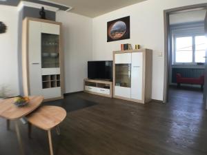 リングスハイムにあるFerienwohnung Alte B3のテーブルとテレビのあるリビングルーム