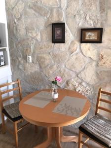 une table en bois avec un vase de fleurs. dans l'établissement Apartment center Roko, à Split