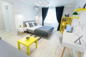 ein Schlafzimmer mit einem Bett und einem gelben Tisch in der Unterkunft Apart-Hotel "LAVINA" in Sumy